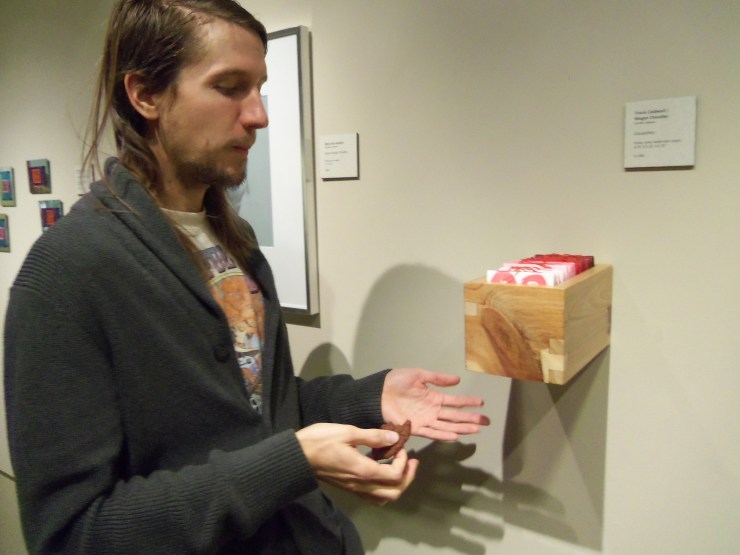 Travis says, "Look ma, no hands," through a mouthful of chocolate cookie.  For what it's worth, the gallery may not know how to display work, but it sure knows where to get the good cookies.  
